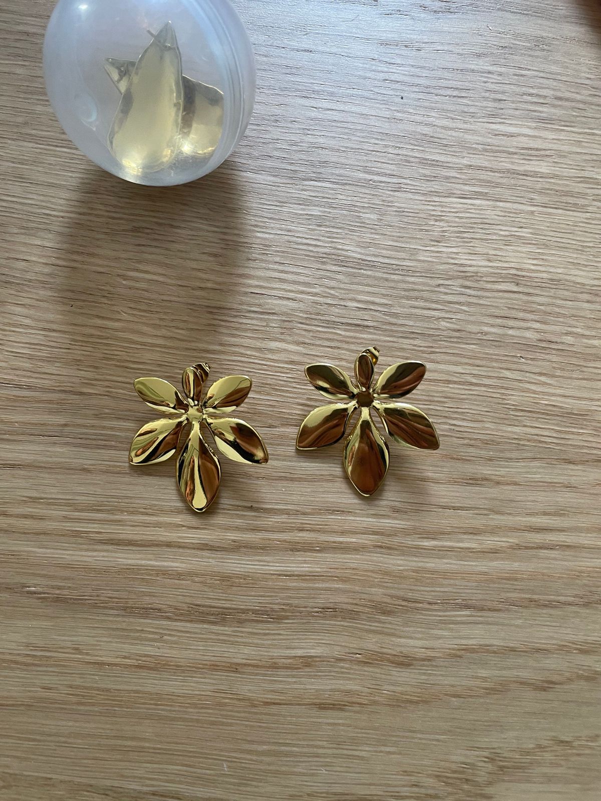 a pair of gold toned flower shaped earrings