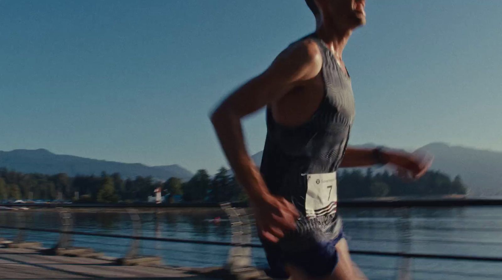 a man running on a boardwalk near a body of water