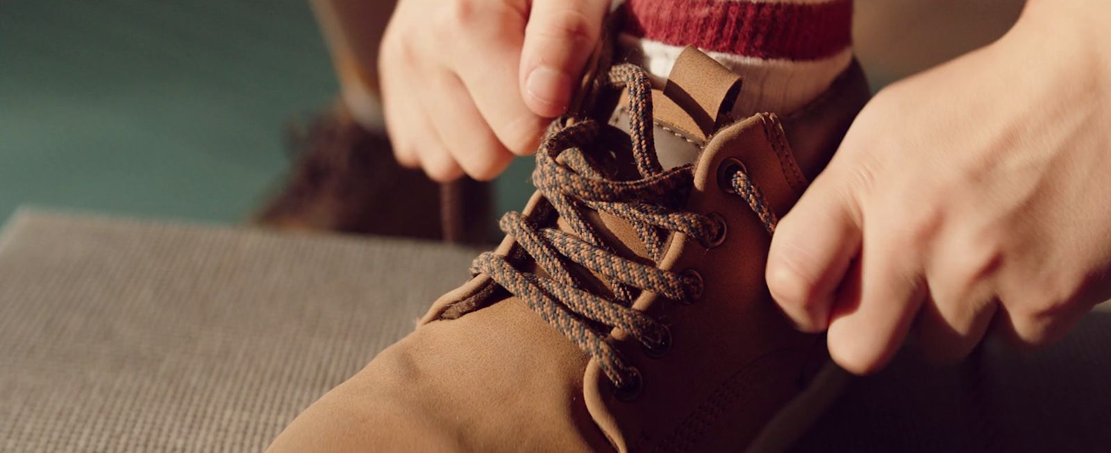 a person tying a shoelace on a pair of shoes