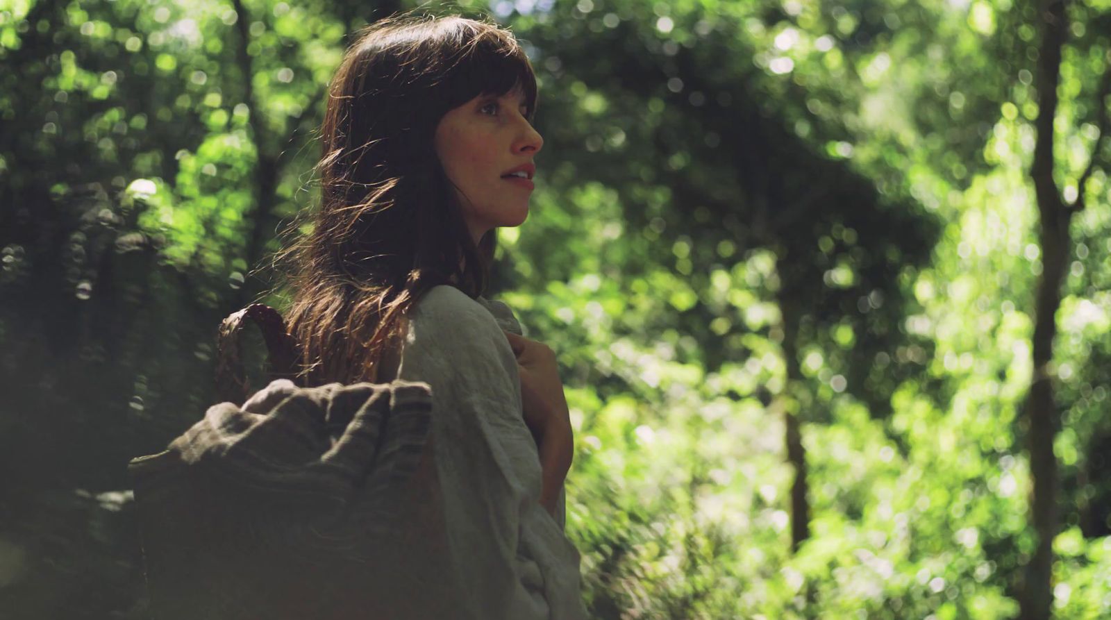 a woman standing in the middle of a forest