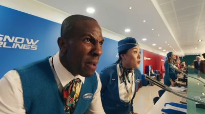 a man in a blue vest and tie sitting next to a woman in a white