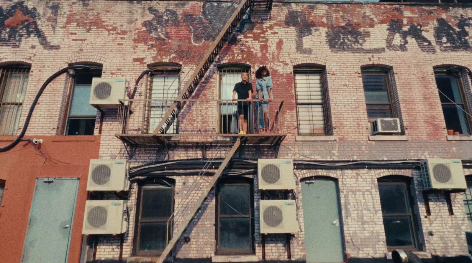 a couple of people standing on a ladder in front of a building