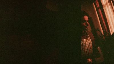 a man standing next to a window in a dark room