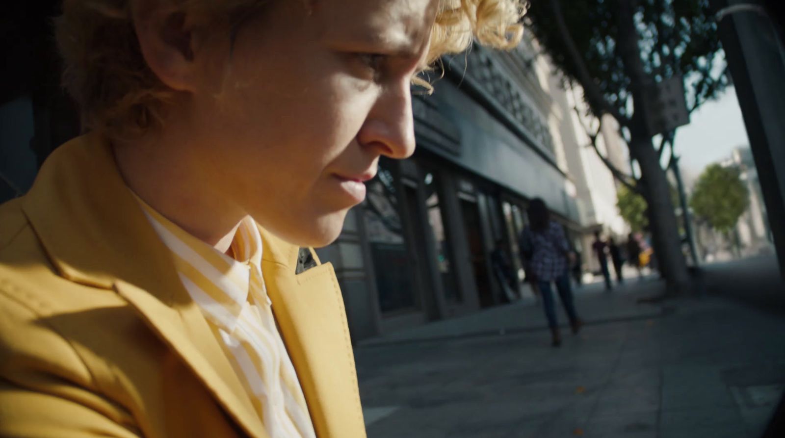 a man in a yellow suit looking at his cell phone