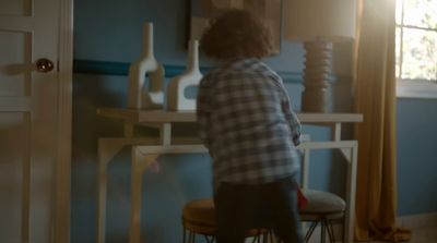 a person sitting on a stool in a room