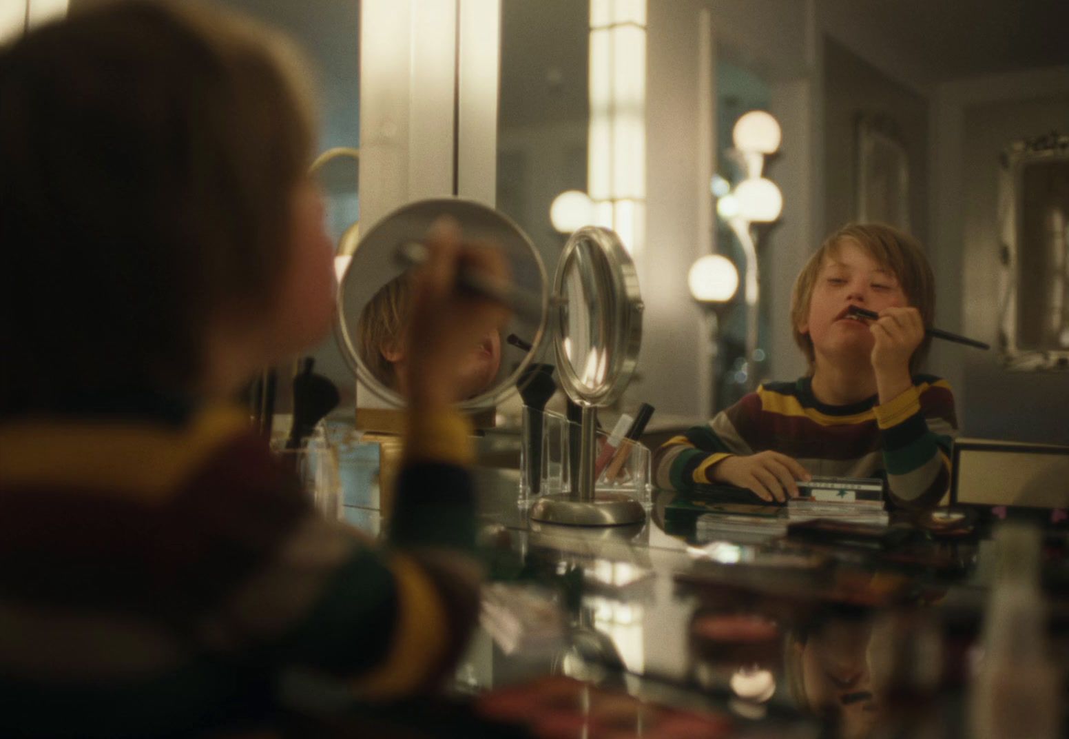 a young girl brushing her teeth in front of a mirror