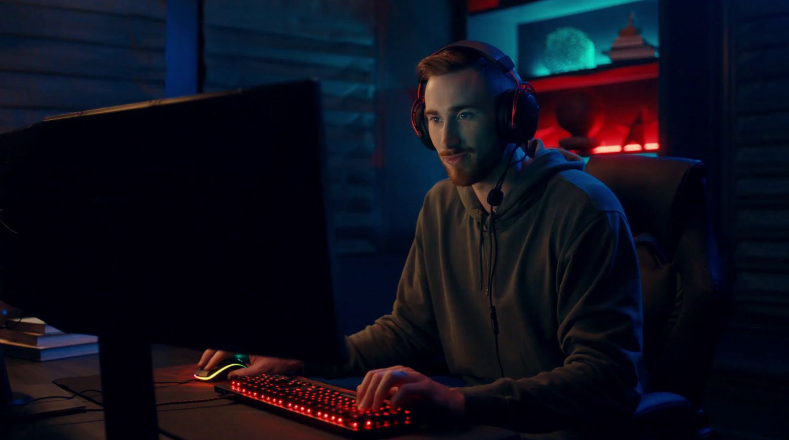 a man sitting at a computer with headphones on