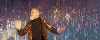 a man standing in front of a curtain with his hands in the air