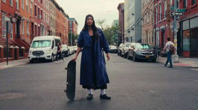 a woman in a blue coat is holding a suitcase