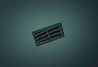 a black vent on a gray wall