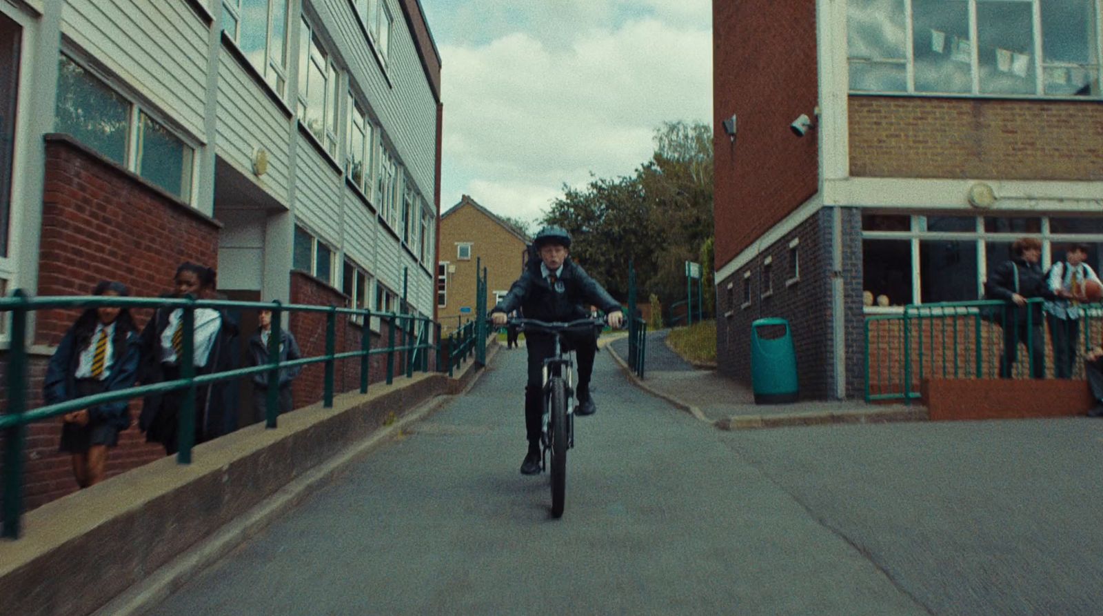 a man riding a bike down a street next to tall buildings