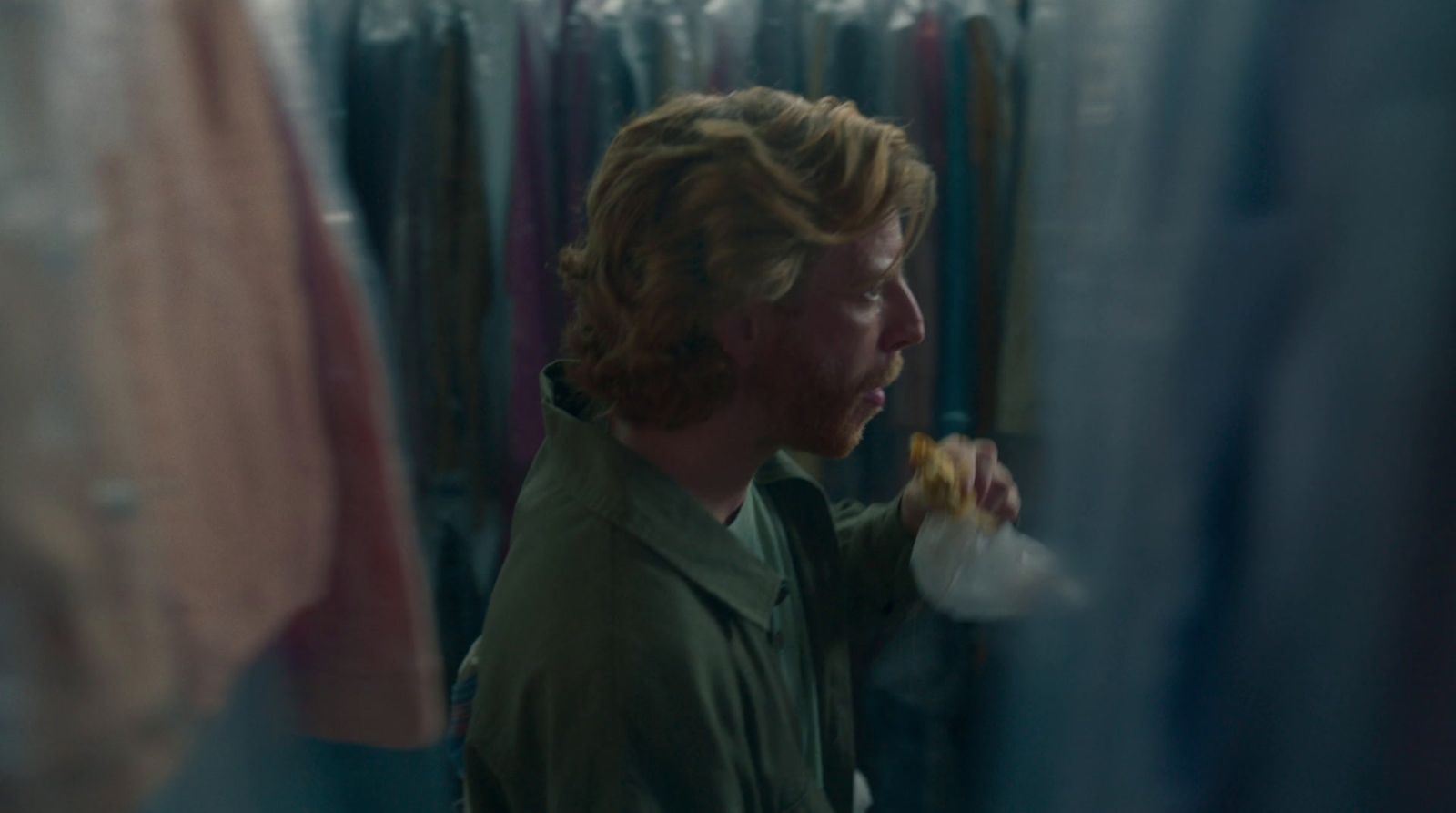 a man standing in front of a rack of clothes