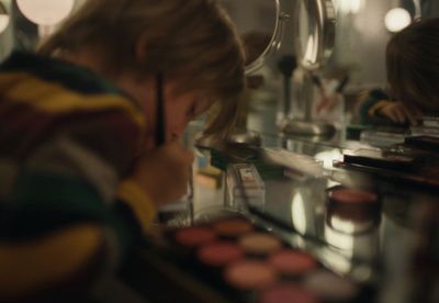 a woman is looking at a mirror with makeup on it