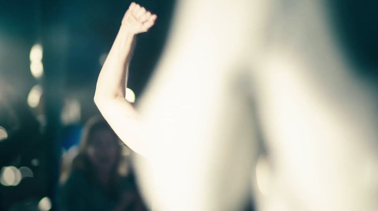 a blurry image of a woman raising her arm