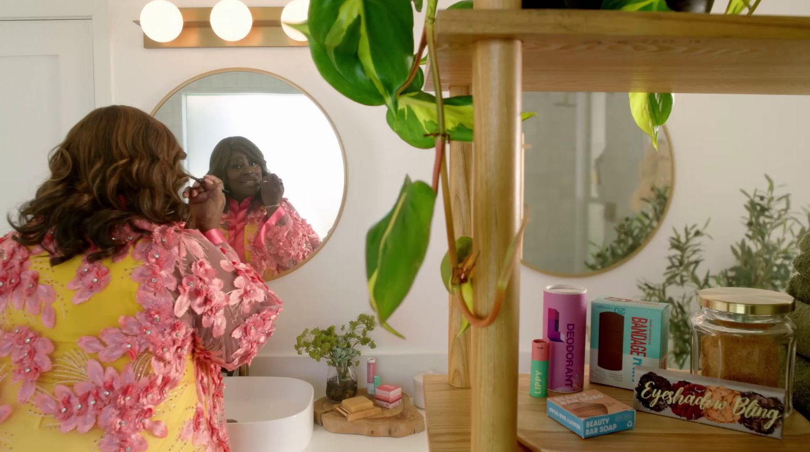 a woman standing in front of a mirror brushing her teeth