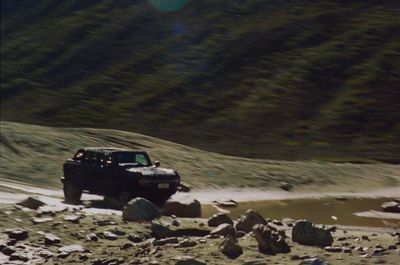 a jeep driving down a dirt road in the mountains