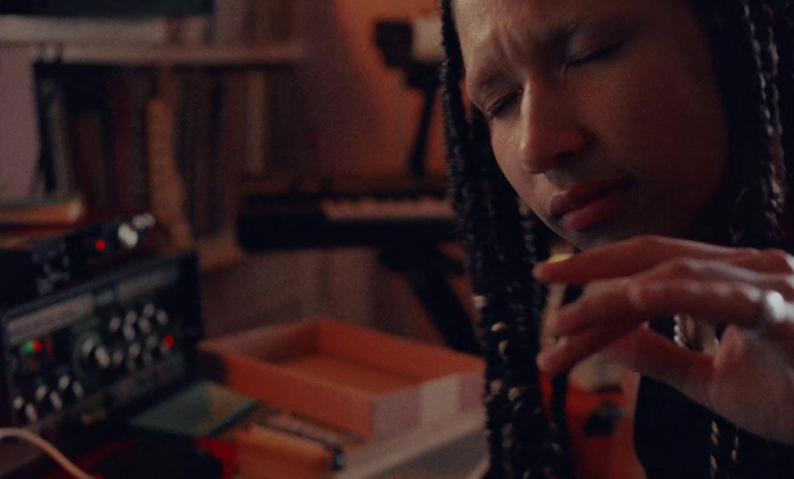 a woman with dreadlocks sitting in front of a radio