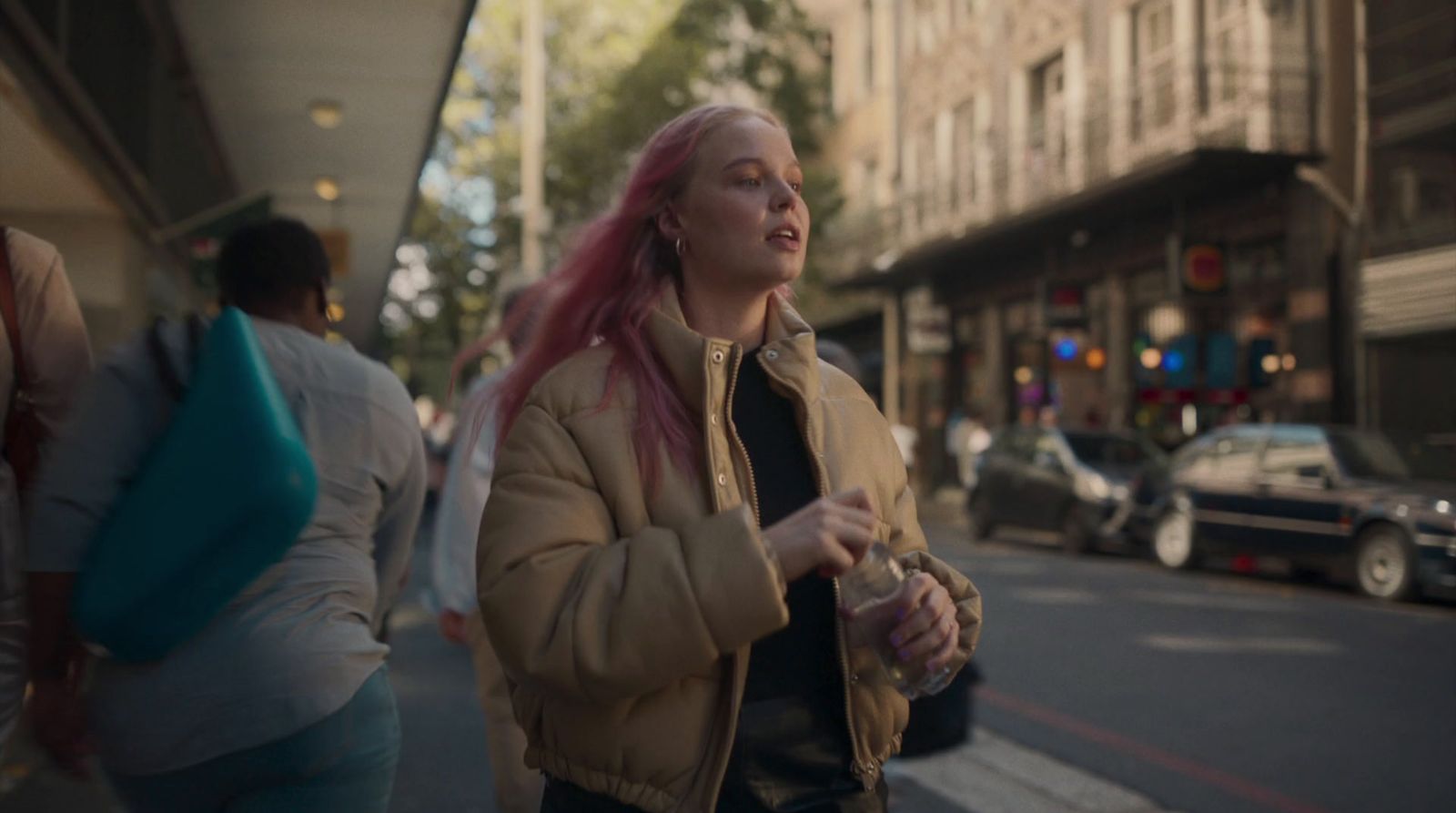 a woman with pink hair walking down the street