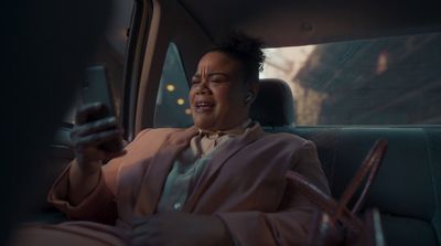 a woman sitting in a car holding a cell phone