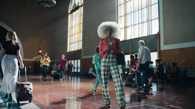 a woman with an afro standing in a large room