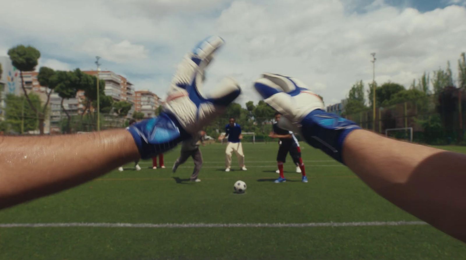 a person wearing blue and white gloves holding a soccer ball