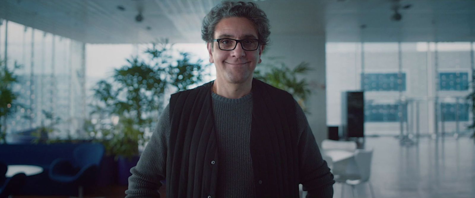 a man wearing glasses standing in a room