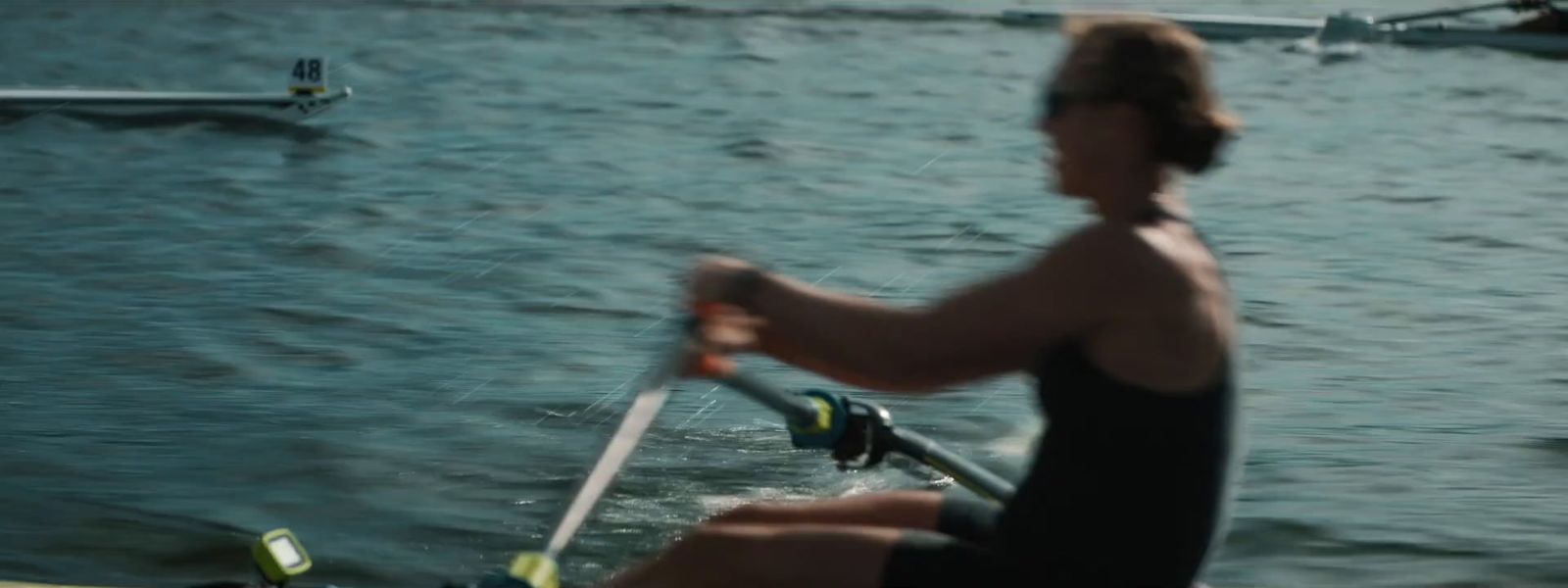 a woman rowing a boat on a body of water