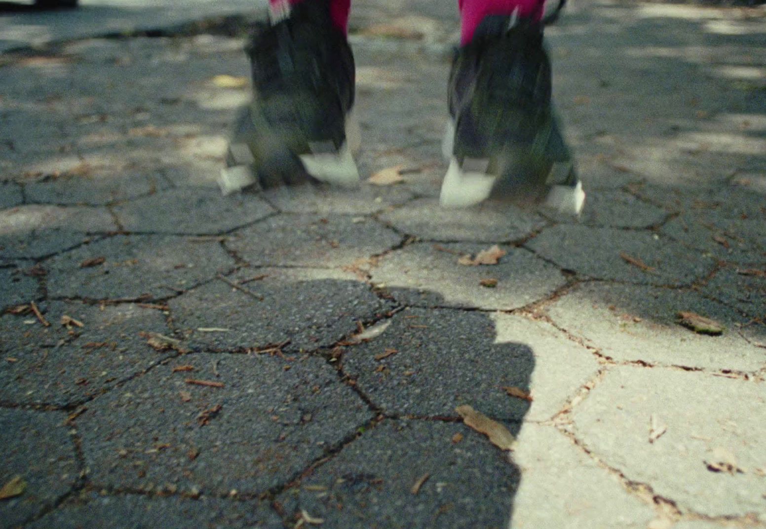 a person standing on a street with their feet in the air