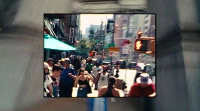 a crowd of people walking down a street next to tall buildings