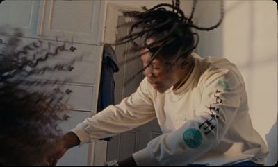 a man with dreadlocks sitting in front of a mirror