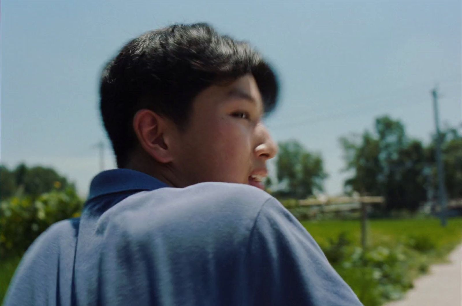 a young man standing on a sidewalk with a frisbee in his hand