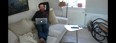 a man sitting on a couch with a laptop