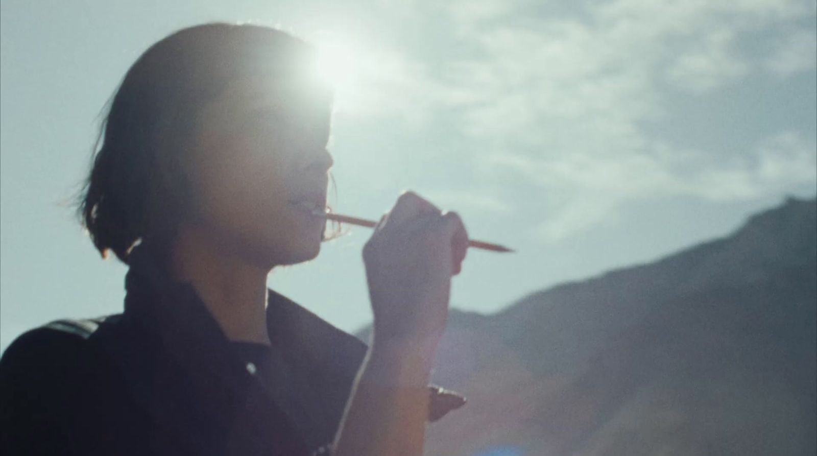 a woman smoking a cigarette in the sun