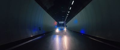 a truck driving down a tunnel at night