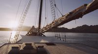 the sun is setting on a sailboat in the water