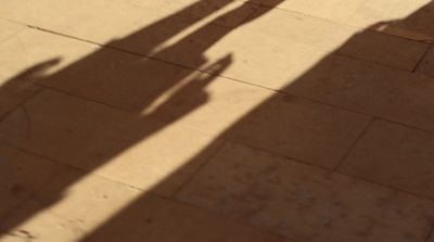 a shadow of a person holding a cell phone