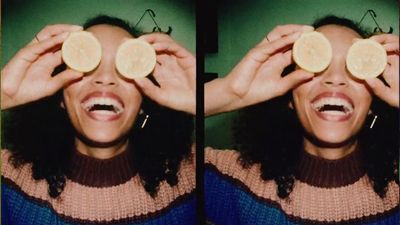 a woman holding a piece of fruit up to her eyes