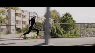 a man running across a bridge next to a tall building