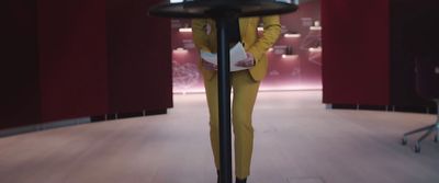 a woman in a yellow suit standing in a room