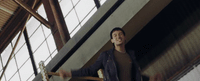 a man in a black jacket standing on a stair case