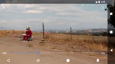 a person sitting on a bench in the middle of a dirt road