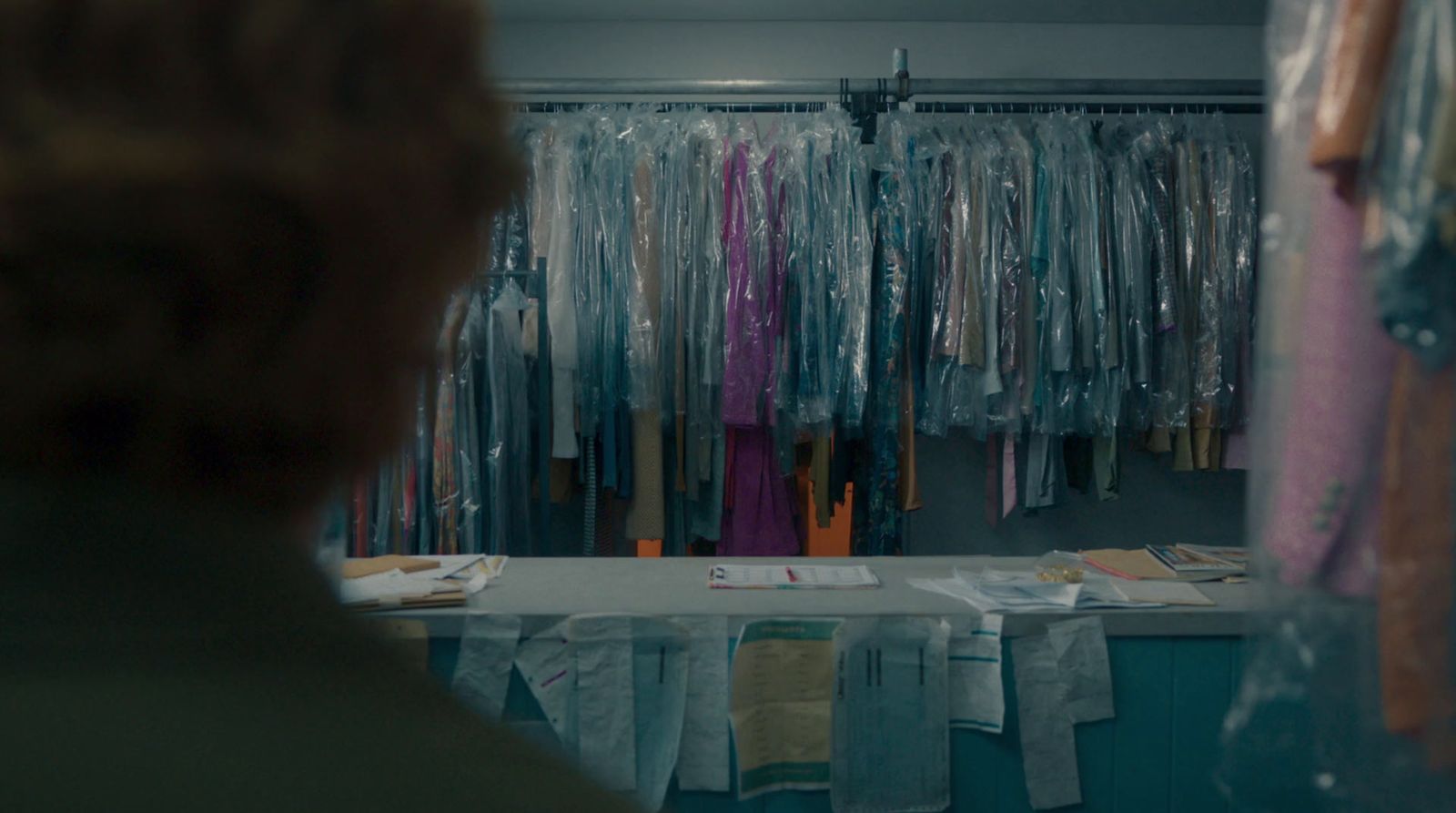 a woman looking at a closet full of clothes