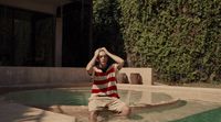 a man sitting on the edge of a pool of water