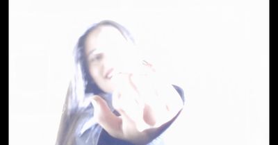 a blurry photo of a woman making a hand gesture