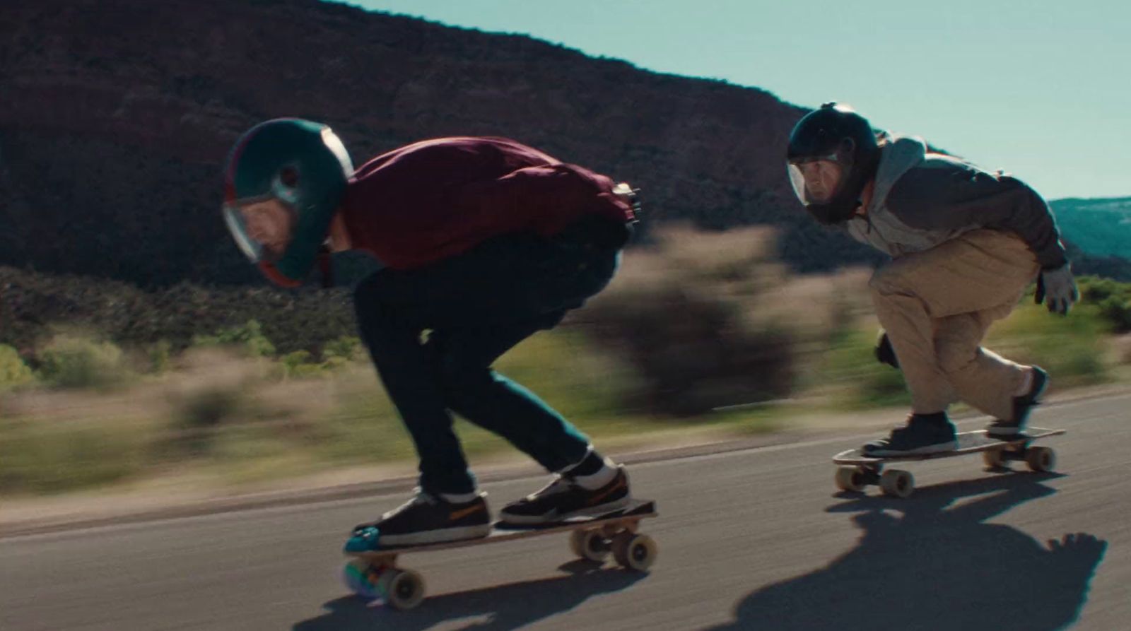 a couple of people riding skateboards down a street