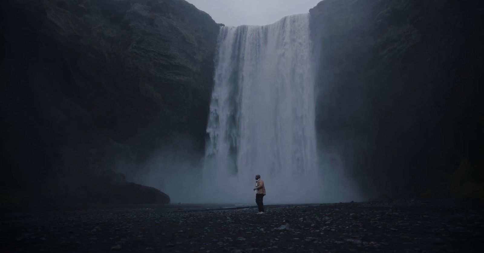 a person standing in front of a waterfall