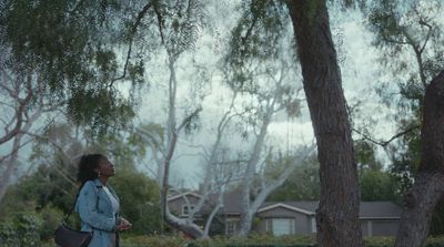 a woman standing in front of a tree