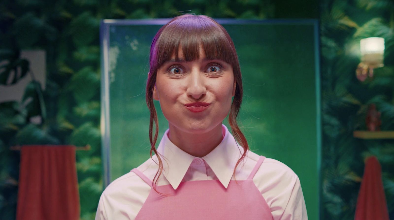 a woman in a pink apron making a funny face