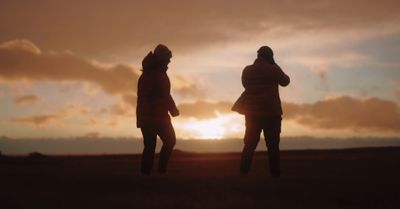 a couple of people that are standing in the grass