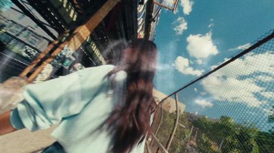 a woman walking across a bridge next to a tall building